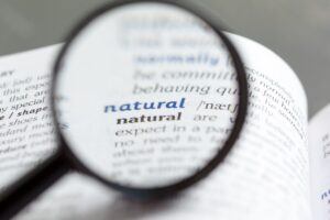 Close-up of a supplement ingredient list highlighting the term "Natural Flavors" — an FDA-permitted label term that can legally hide up to 100 undisclosed additives without individual disclosure.