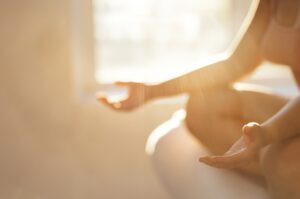 Person sitting in warm morning light holding a mug, illustrating the quiet reflective experience of noticing that B-vitamin supplements may be contributing to anxiety.