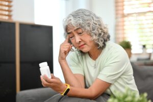 Person reading a B-vitamin supplement label with a skeptical, thoughtful expression, questioning common methylation claims