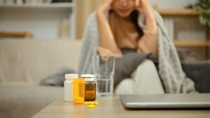 Woman experiencing anxiety and panic at a table with methylated B-vitamin supplements — a common reaction for methyl-sensitive adults